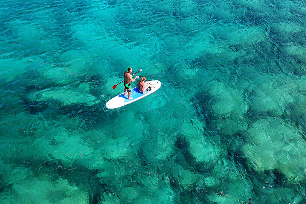 two people on Stand up paddle board in clear calm water -Paddle boarding on the east coast of Sri Lanka in Trincomalee, Nilaveli
